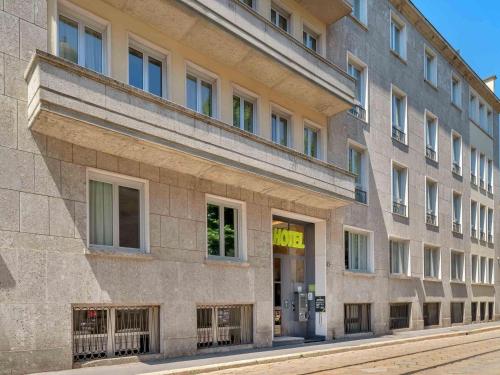 a large brick building on a city street at B&B Hotel Milano Sant'Ambrogio in Milan