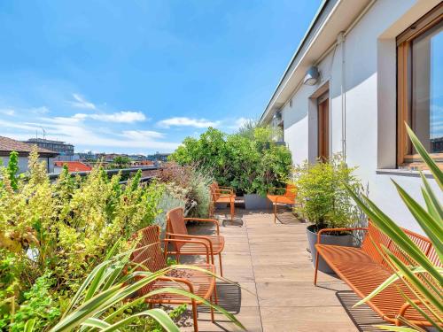 a patio with benches and plants on a building at B&B Hotel Milano Sant'Ambrogio in Milan