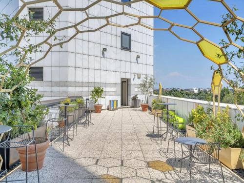 a patio with chairs and tables on a building at B&B Hotel Milano Cenisio Garibaldi in Milan