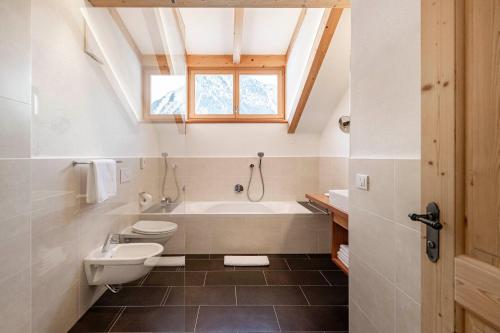 a bathroom with a tub and a toilet and a sink at Christlrumerhof in Brunico