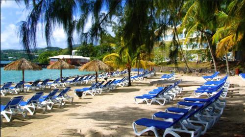 a bunch of chairs and umbrellas on a beach at studio hôtel Caraypu in Lazaret