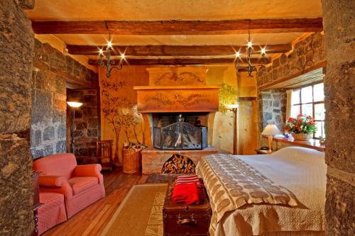 a bedroom with a large bed and a fireplace at Hacienda San Agustin de Callo in Lasso