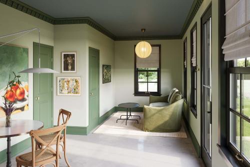 ein Wohnzimmer mit grünen Wänden sowie einem Tisch und Stühlen in der Unterkunft Wild Indigo - Upscale 2 Bedroom Villa at Petite Acres in New Buffalo