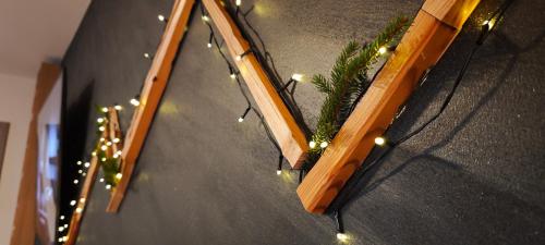 Apartmán 4, Pstruží, Krušné hory في Merklín: سكة خشبية مع أضواء عيد الميلاد ونبات