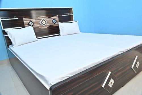 a bed with white sheets and pillows on it at Royal hotel in Hardoī