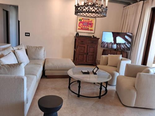 卡波圣卢卡斯Exquisite escape villas的带沙发、桌子和电视的客厅