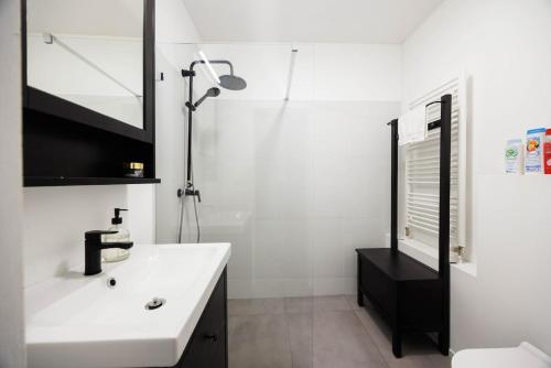 a white bathroom with a sink and a shower at Cute Apartment in the heart of Old Town in Košice