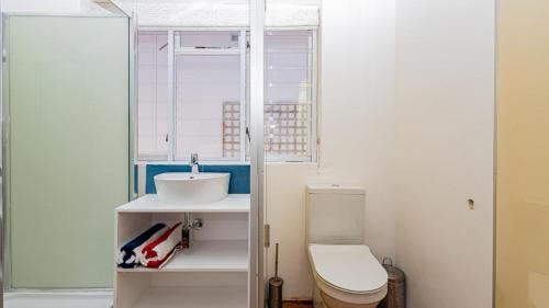 a bathroom with a toilet and a sink at Blossom Boutique Guesthouse in Muizenberg