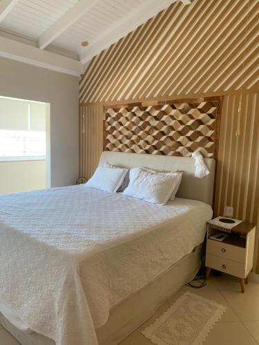 a bedroom with a large bed with a wooden headboard at Casa amarela in Navegantes