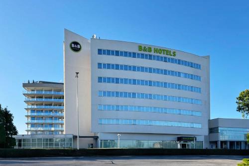 a building with a sign on the side of it at B&B HOTEL Cuneo Cristal in Cuneo