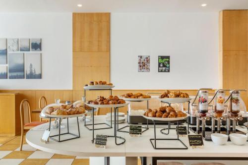 a table with several trays of food on it at B&B HOTEL Cuneo Cristal in Cuneo