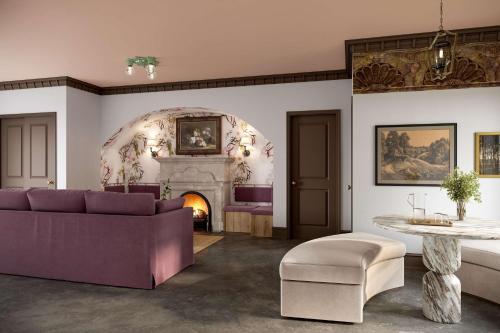 Pied A Terre - Bunk House Villa at Petite Acres في نيو بافالو: غرفة معيشة مع أريكة أرجوانية ومدفأة