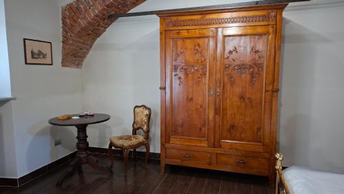 a wooden cabinet in a room with a table at Cascina Tetto Cavallo Monolocale Rustico in Revello