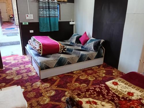 1 Schlafzimmer mit 2 Betten und bunter Bettwäsche in der Unterkunft TTN - The Trekker's Nest in Jyotirmath