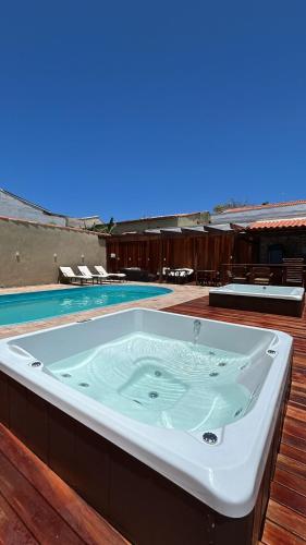 a jacuzzi tub on a deck next to a pool at Pousada Loft Praia dos Anjos in Arraial do Cabo