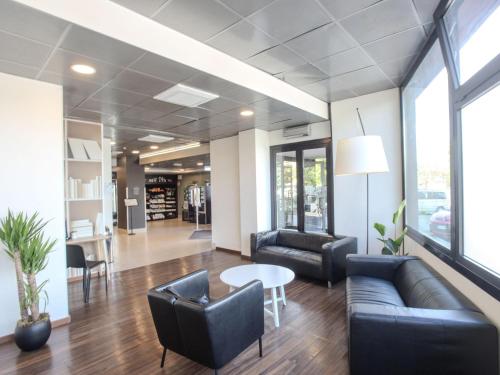 eine Lobby mit Sofas und einem Tisch und Stühlen in der Unterkunft B&B Hotel Firenze Novoli in Florenz