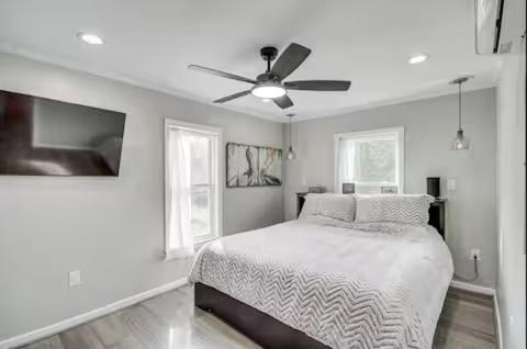 ein weißes Schlafzimmer mit einem Bett und einem Deckenventilator in der Unterkunft Luxury Waterfront property in Bay Saint Louis