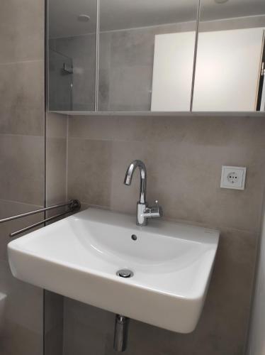 un lavabo blanc dans une salle de bain avec des armoires dans l'établissement FeWo Garmisch, à Garmisch-Partenkirchen