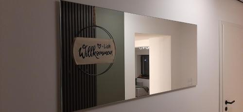 uno specchio in bagno con un cartello sopra di Primslodge a Nalbach