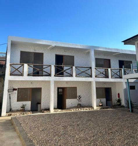 桑给巴尔Spice Garden Lodge B&B的一栋白色建筑，顶部有阳台
