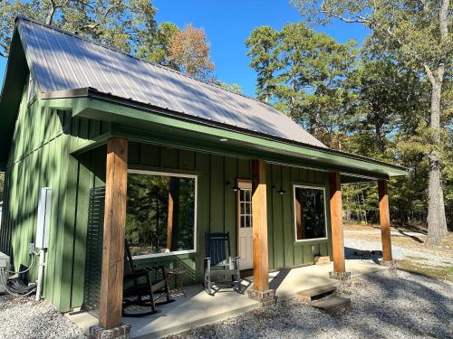 a green tiny house with a gambrel roof at The Cabins at Northwoods Trails in Hot Springs
