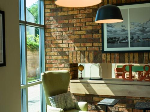a living room with a brick wall and a chair at B&B HOTEL Ipswich in Ipswich
