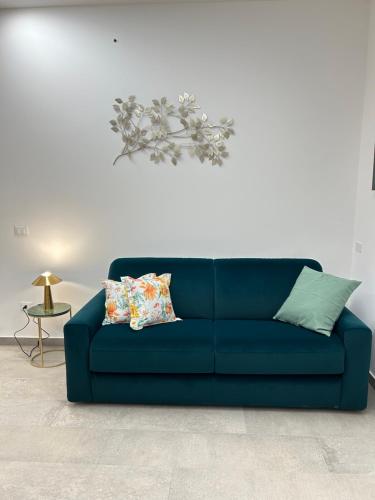 a blue couch with two pillows in a living room at Mongibello Apartment in Belpasso