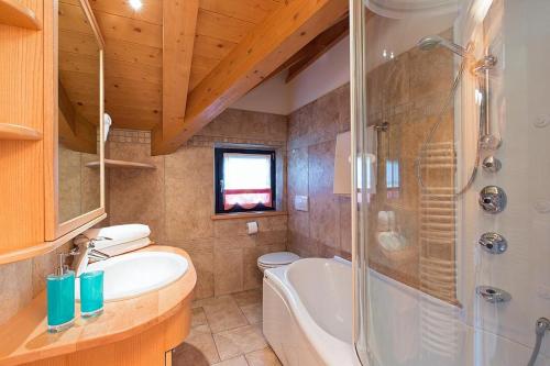 ein Bad mit einer Badewanne, einem Waschbecken und einer Dusche in der Unterkunft Art Apartments Kandinsky in Livigno