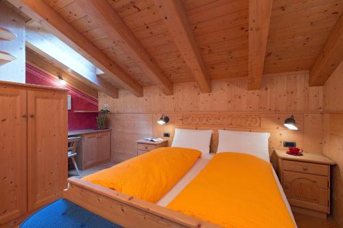 Cette chambre dispose d'un grand lit et de plafonds en bois. dans l'établissement Art Apartments Kandinsky, à Livigno