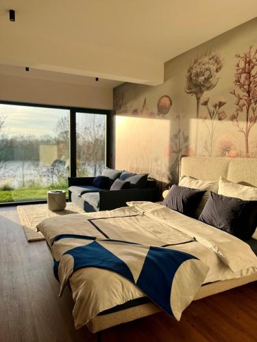 ein Schlafzimmer mit einem großen Bett und einer Couch in der Unterkunft DOBRE 23j - Dom nad jeziorem, z basenem i linią brzegową in Wrzeszczewo