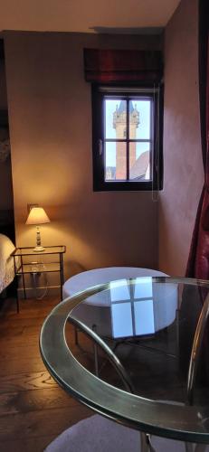 una camera con un tavolo in vetro e una finestra di La Tour de la Chapelle - Parking privé a Obernai