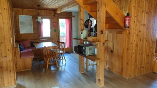a living room with a kitchen and a table with a microwave at Chalet Valdonga in Flumserberg