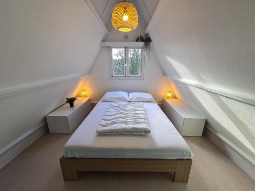 1 dormitorio con 1 cama con 2 luces y una ventana en Sequoia Duo 2 chalets voisins, familles,amis,détente, en Durbuy