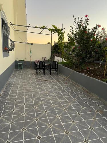 a patio with two black chairs and a table at Dar diyafa kannoua in Tangier