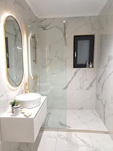 a white bathroom with a sink and a mirror at Noble Suite in Şelimbăr