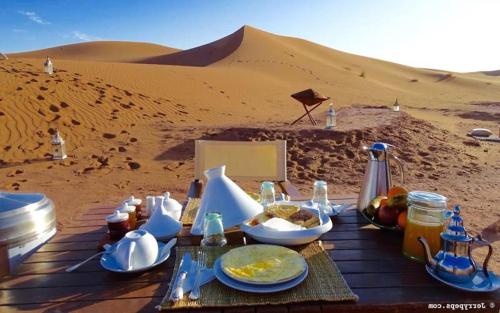 a table with food on it in the desert at Camp Ayour Mhamid in Mhamid