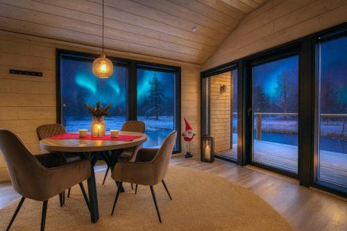 Un comedor con mesa y sillas y ventanas. en Palojärven Lomakeskus, en Sonka