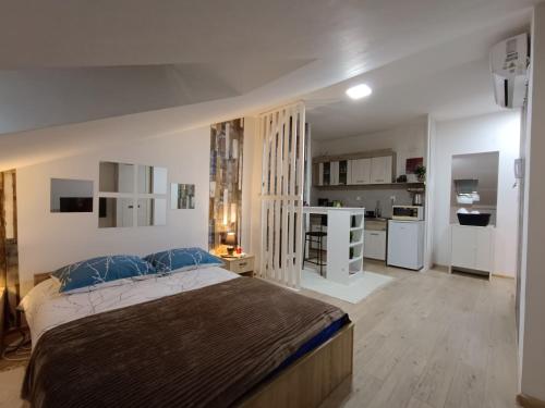 ein Schlafzimmer mit großem Bett und eine Küche in der Unterkunft Apartmani S - DSN in Kraljevo