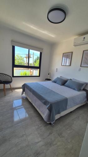 a bedroom with a large bed and a large window at MONACO Departamento PA in Federación