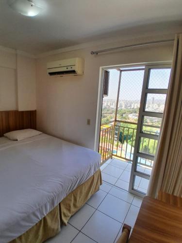 a bedroom with a bed and a large window at residencial diroma exclusive in Caldas Novas