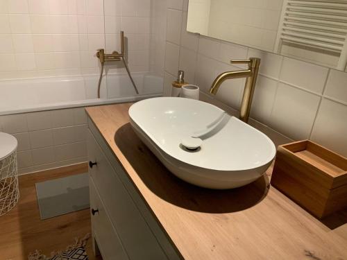 een badkamer met een witte wastafel op een houten aanrecht bij Apartment mit Garten - Garden view in Kleinmachnow