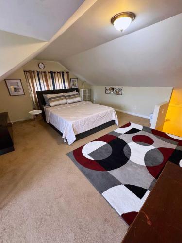 een slaapkamer met een groot bed en een tapijt bij Natvy Alpha Suite - 3 Bedroom in Munhall