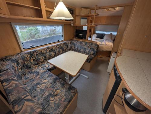 an interior of an rv with a couch and a table at Wohnwagen mit feststehendem Vorzelt in Fehmarn