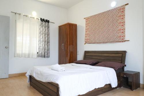 a bedroom with a bed and a wooden cabinet at ll MOCKTAIL VILLA ll AC ll PRIATE POOL ll in Lonavala