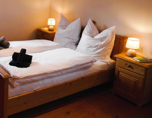 a bedroom with a bed with white sheets and pillows at Bodenschneidsuiten Das Gschwandler in Tegernsee