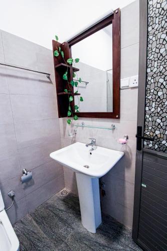 a bathroom with a sink and a mirror at Harbour View Resort & Apartment in Ambalangoda