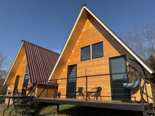 a house with a metal roof on a deck at Aroma of the forest in Martvili