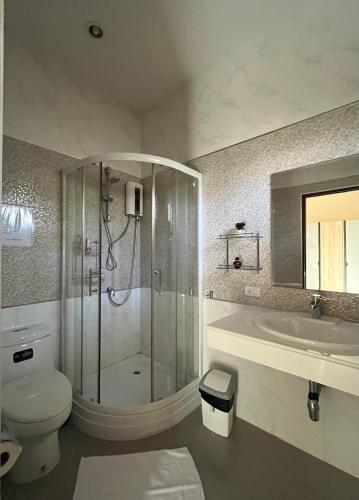 a bathroom with a shower and a toilet and a sink at Project 17 B&B in Hua Hin