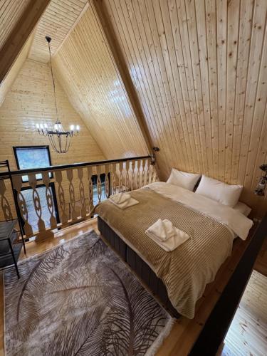 a large bed in a room with a wooden ceiling at Aroma of the forest in Martvili