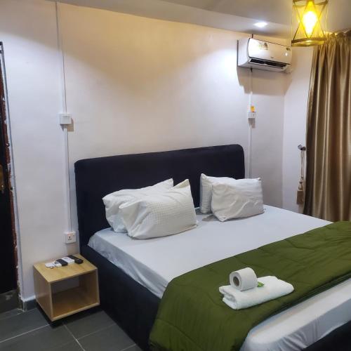a bedroom with a bed with two towels on it at Weltons Apartments in Ikeja